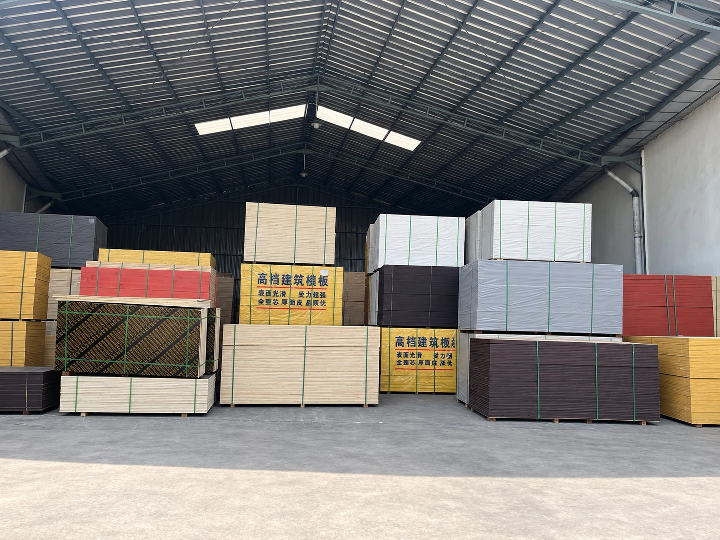 Berbagai jenis plywood tersusun di dalam gudang