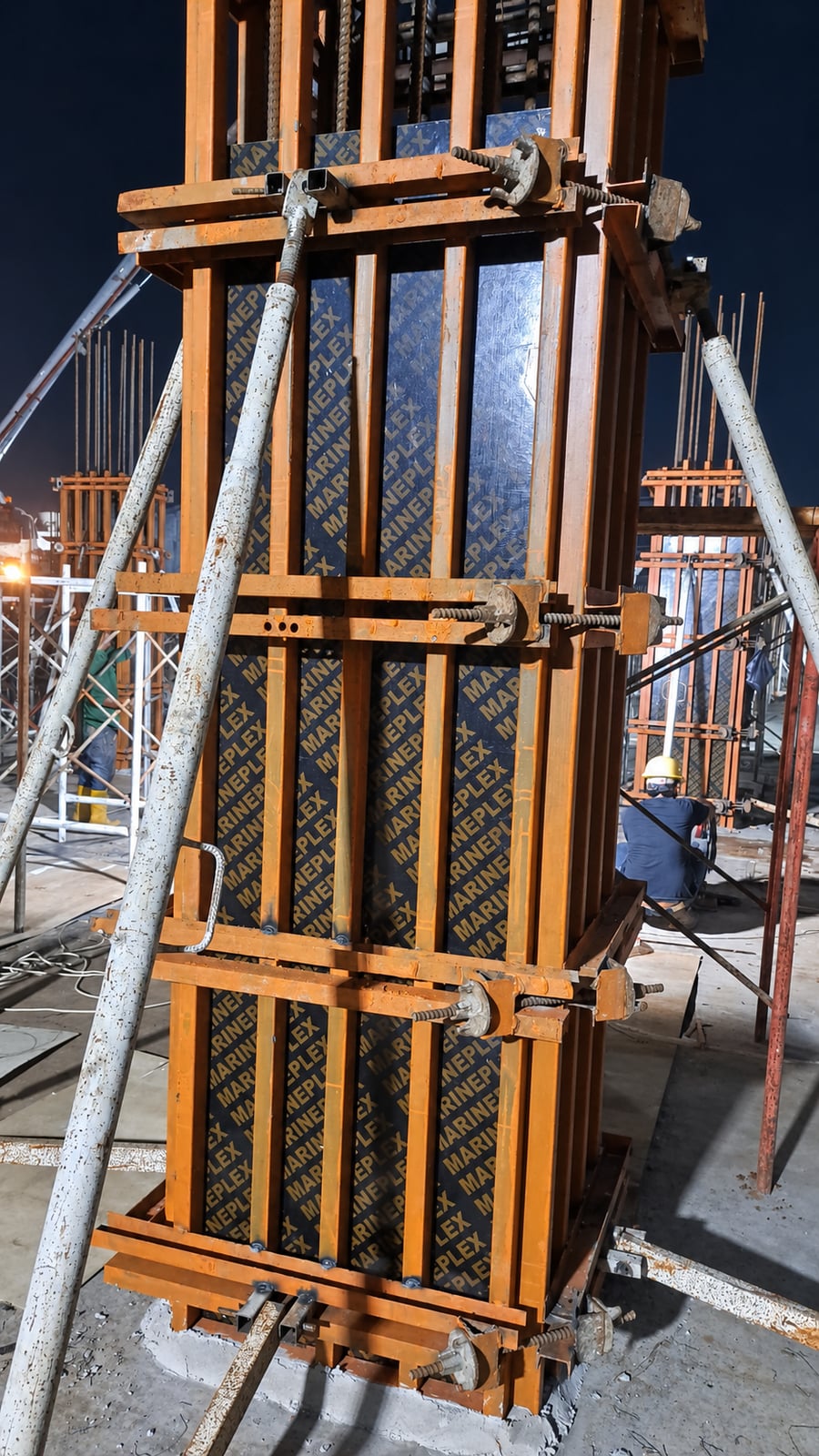 Foto disunting: bekisting kolom plywood MARINEPLEX di lokasi konstruksi pada malam hari